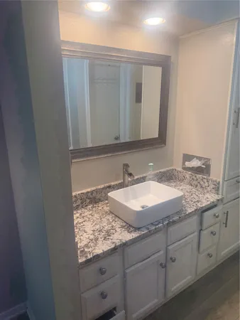 a bathroom with a granite countertop sink and a mirror