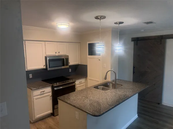 a kitchen with kitchen island a sink stainless steel appliances and cabinets