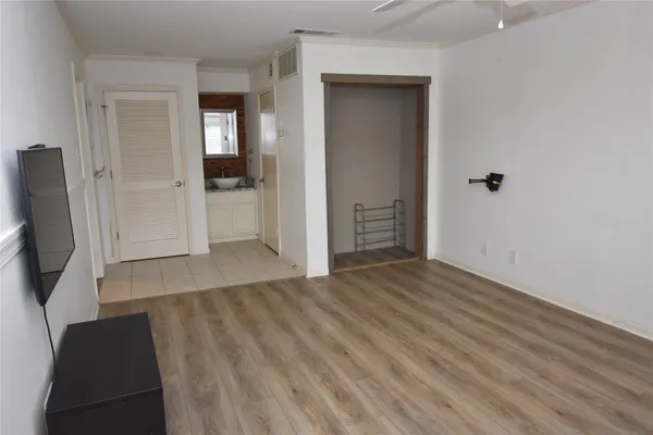 wooden floor in a hall with an entryway and a cabinet
