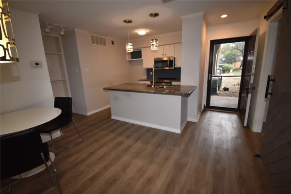 a kitchen with kitchen island wooden floors and stainless steel appliances