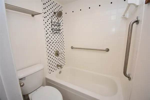 a bathroom with a shower a toilet and a bathtub