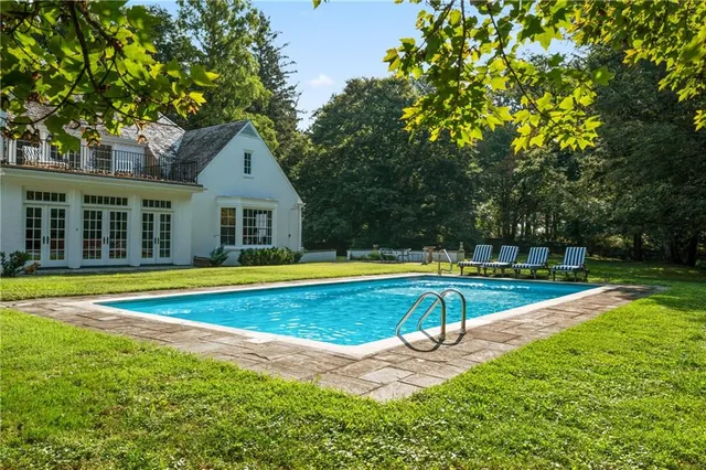 a view of a house with swimming pool and a yard