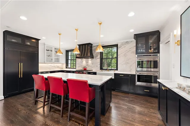 a kitchen with stainless steel appliances kitchen island granite countertop a table chairs stove and refrigerator