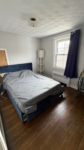 a bed sitting in a bedroom next to a window