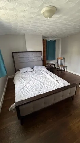 a bed sitting in a bedroom next to a window