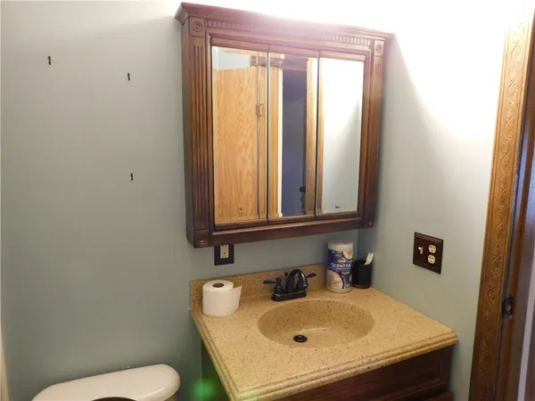 a bathroom with a sink a toilet and mirror