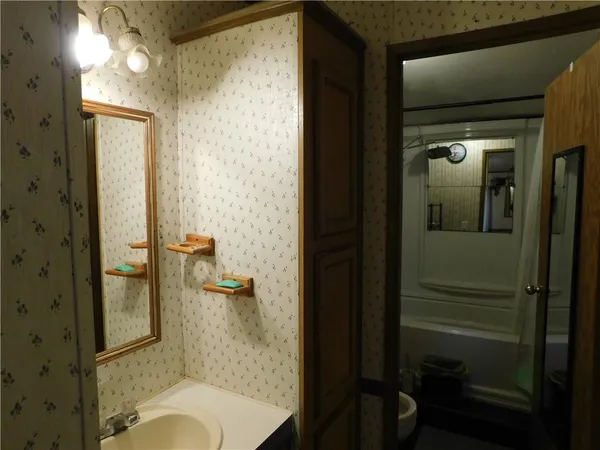 a bathroom with a granite countertop sink mirror and toilet