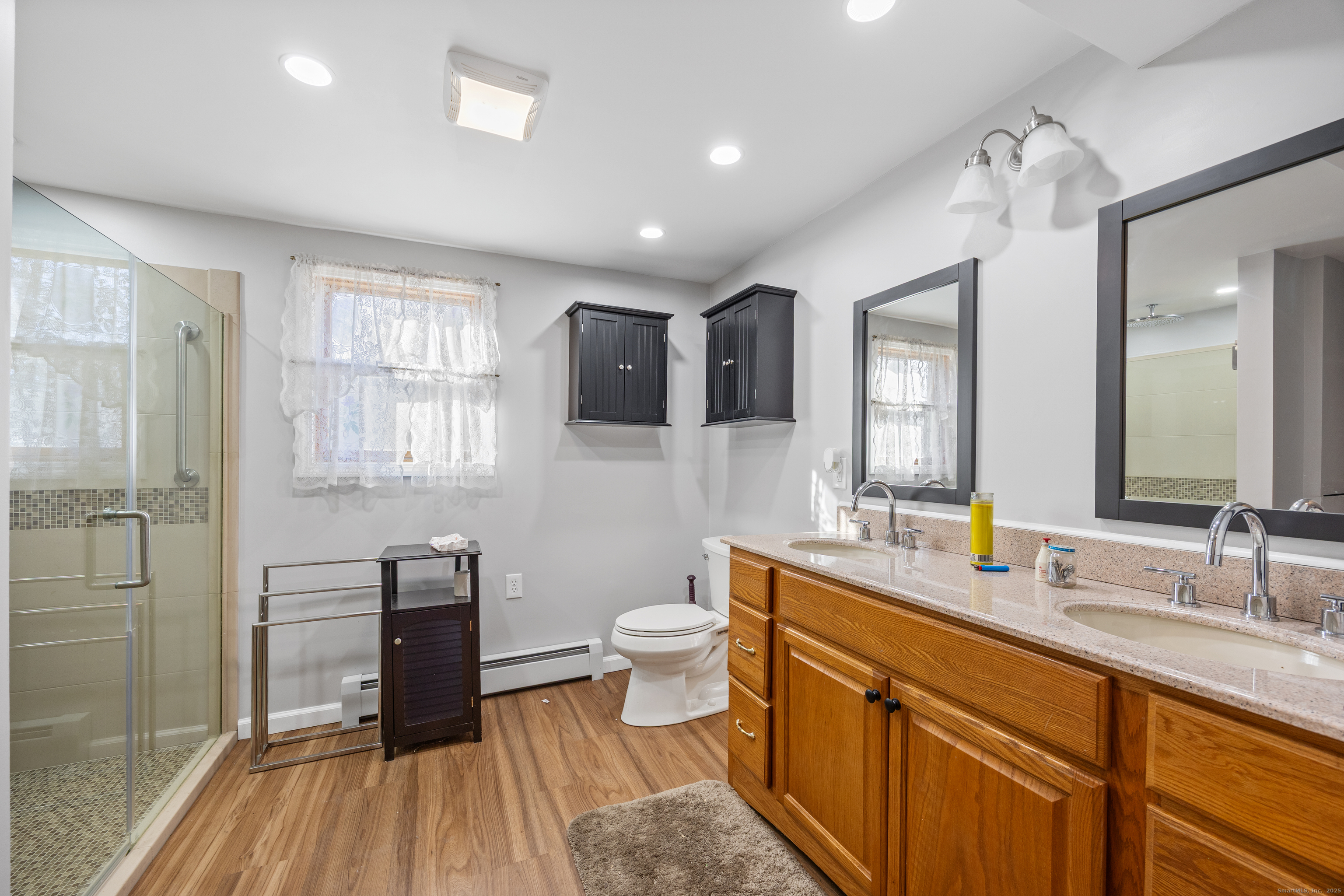 1557 Wolcott Road Wolcott, CT 06716 - Photo 11 of 18 a spacious bathroom with a double vanity sink a large mirror and toilet