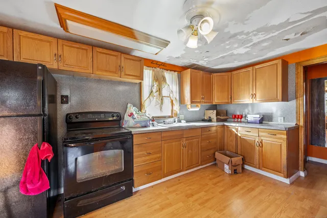 a kitchen with kitchen island granite countertop a stove top oven cabinetry a chimney and a center island