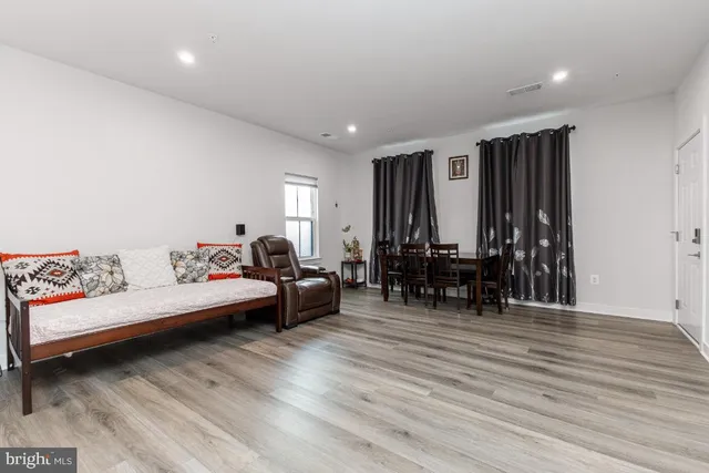 a kitchen with stainless steel appliances a table chairs and a refrigerator