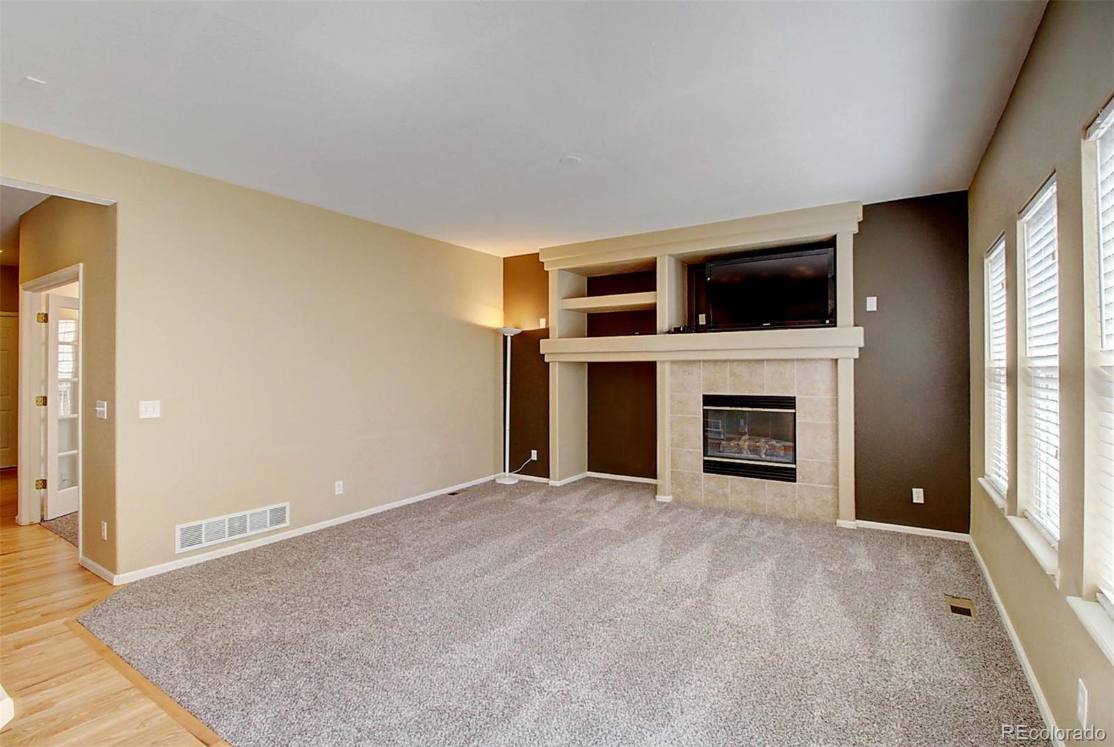 5794 South Rome Street Aurora, CO 80015 - Photo 11 of 37 a view of a livingroom with an empty space and a fireplace