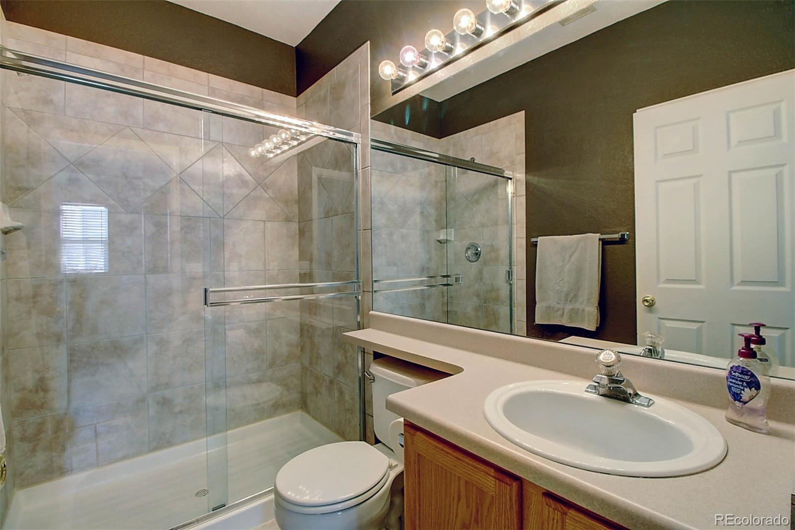 5794 South Rome Street Aurora, CO 80015 - Photo 32 of 37 a bathroom with a sink a toilet and shower