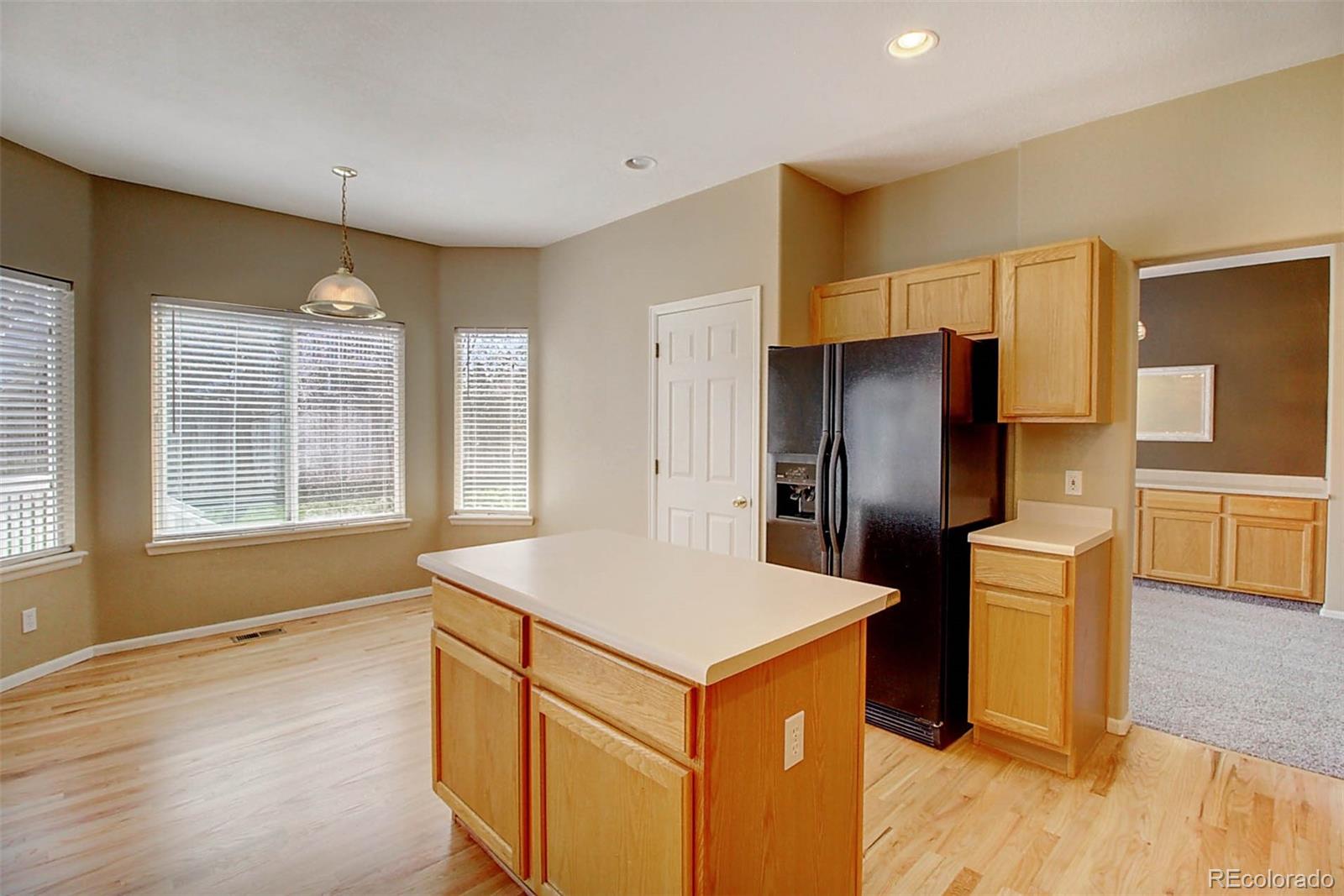 5794 South Rome Street Aurora, CO 80015 - Photo 7 of 37 a kitchen with stainless steel appliances granite countertop a refrigerator a sink a stove and a wooden floors