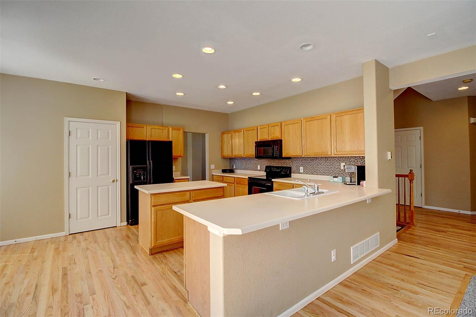 5794 South Rome Street Aurora, CO 80015 - Photo 8 of 37 a large room with stainless steel appliances lots of counter space and a refrigerator