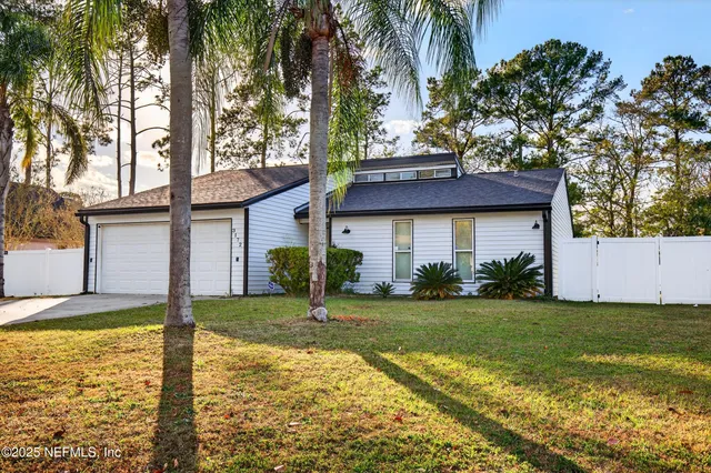 a front view of house with yard and garage