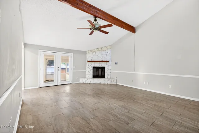 a view of empty room with wooden floor and fireplace