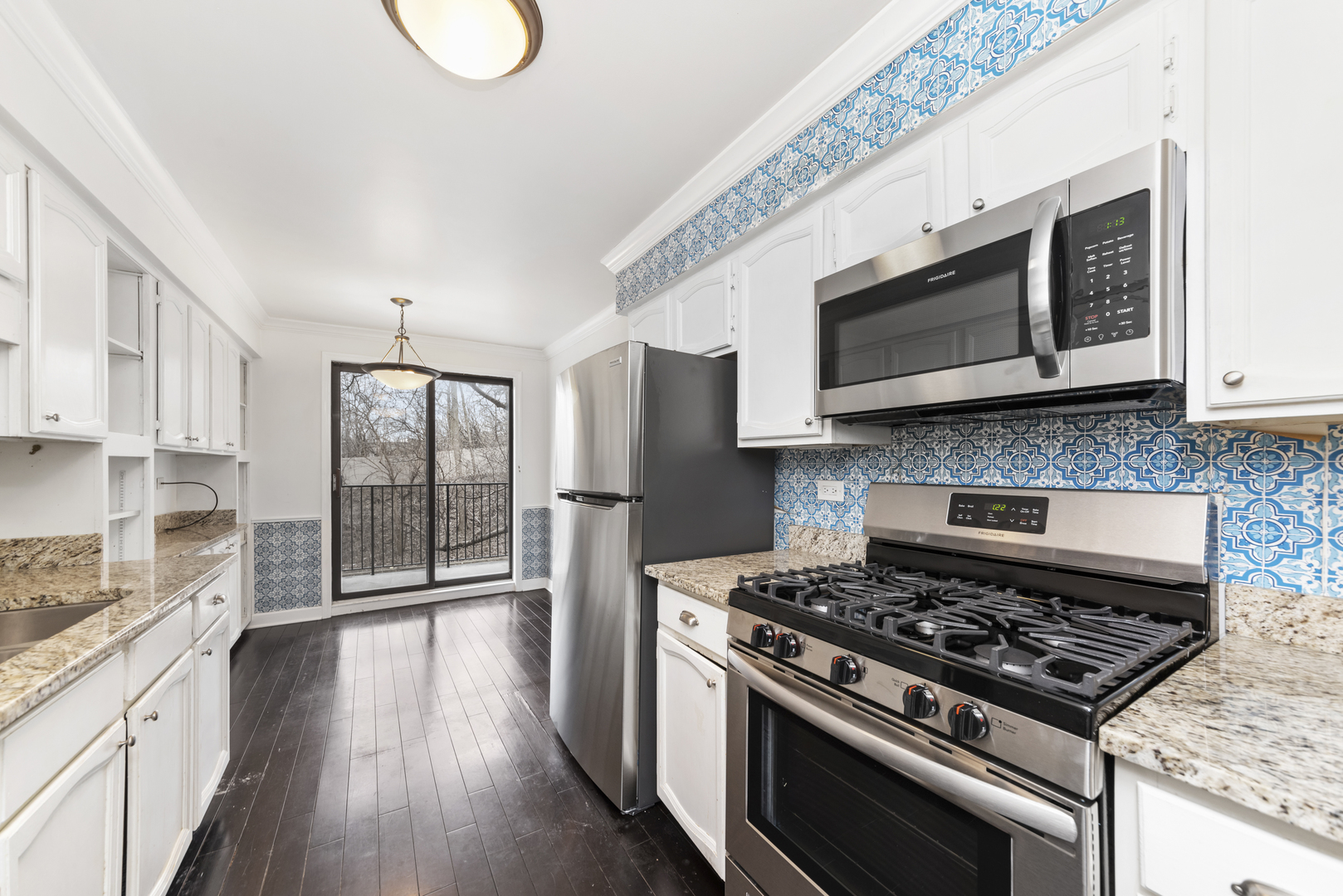 1-s150 Spring Road, Unit 2D Oak Brook, IL 60181 - Photo 5 of 22 a kitchen with stainless steel appliances a stove a microwave cabinets and a wooden floor