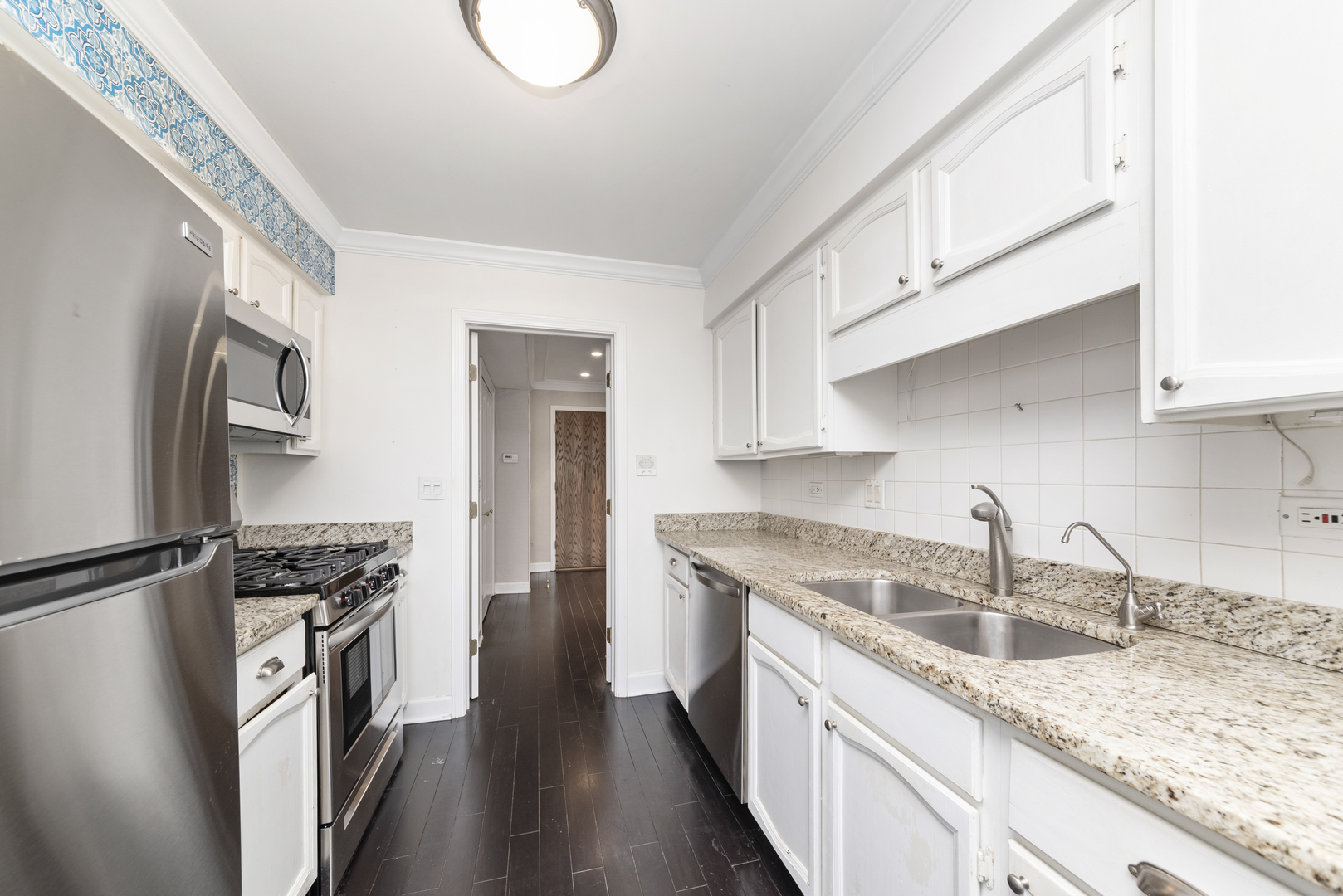 1-s150 Spring Road, Unit 2D Oak Brook, IL 60181 - Photo 6 of 22 a kitchen with stainless steel appliances granite countertop a sink stove and refrigerator