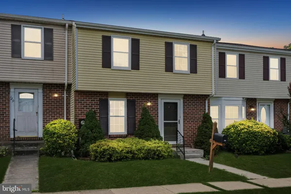 a view of a brick house with a yard
