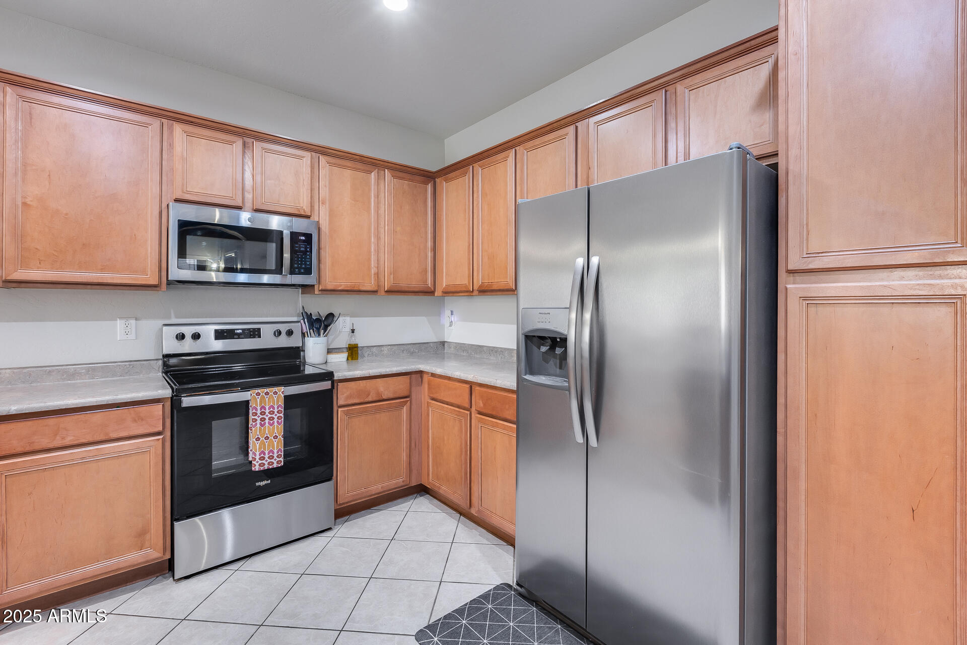 14229 West Calavar Road Surprise, AZ 85379 - Photo 12 of 44 a kitchen with granite countertop a refrigerator and a stove top oven