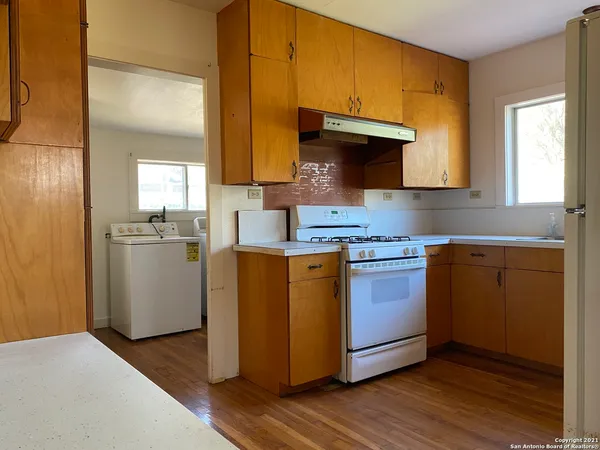 a kitchen with stainless steel appliances granite countertop a sink a stove and a refrigerator