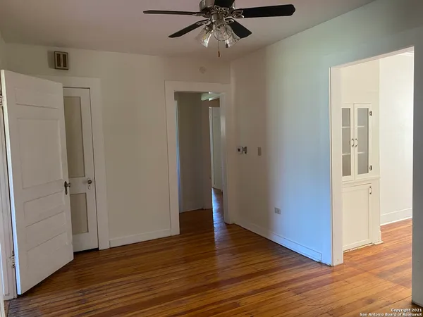 a view of an empty room with wooden floor