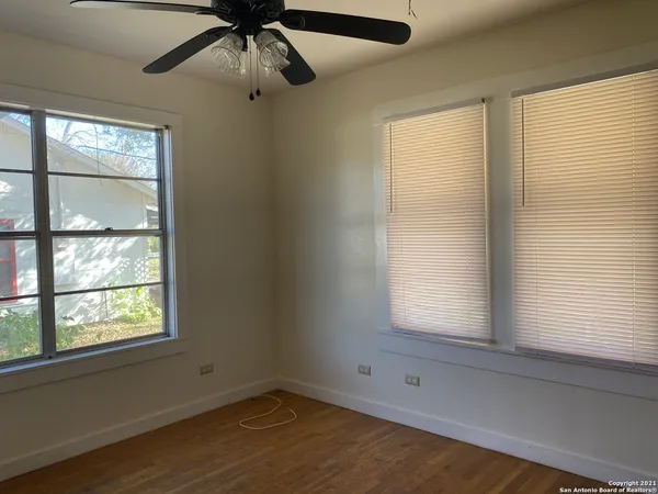 a view of empty room with window and ceiling fan