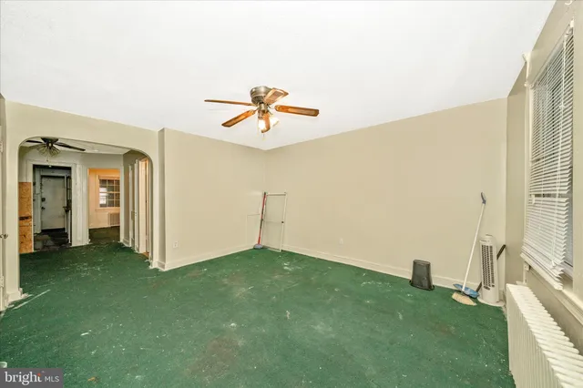 a view of a big room with windows and chandelier fan