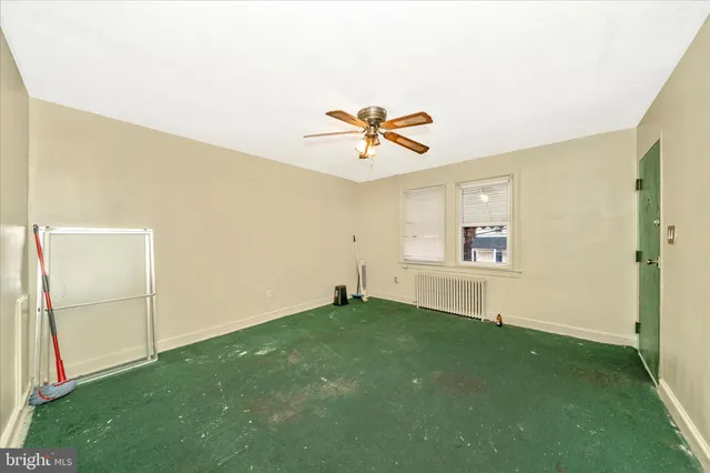 a view of an empty room with window and a ceiling fan