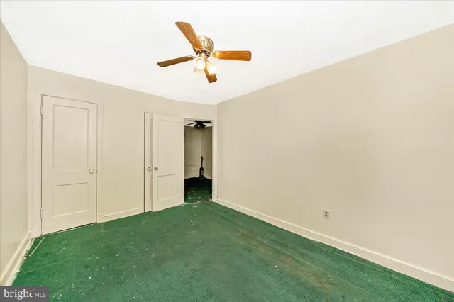 a view of a big room with a ceiling fan and carpet