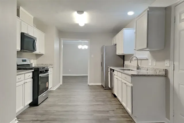 a kitchen with stainless steel appliances granite countertop a sink stove and refrigerator