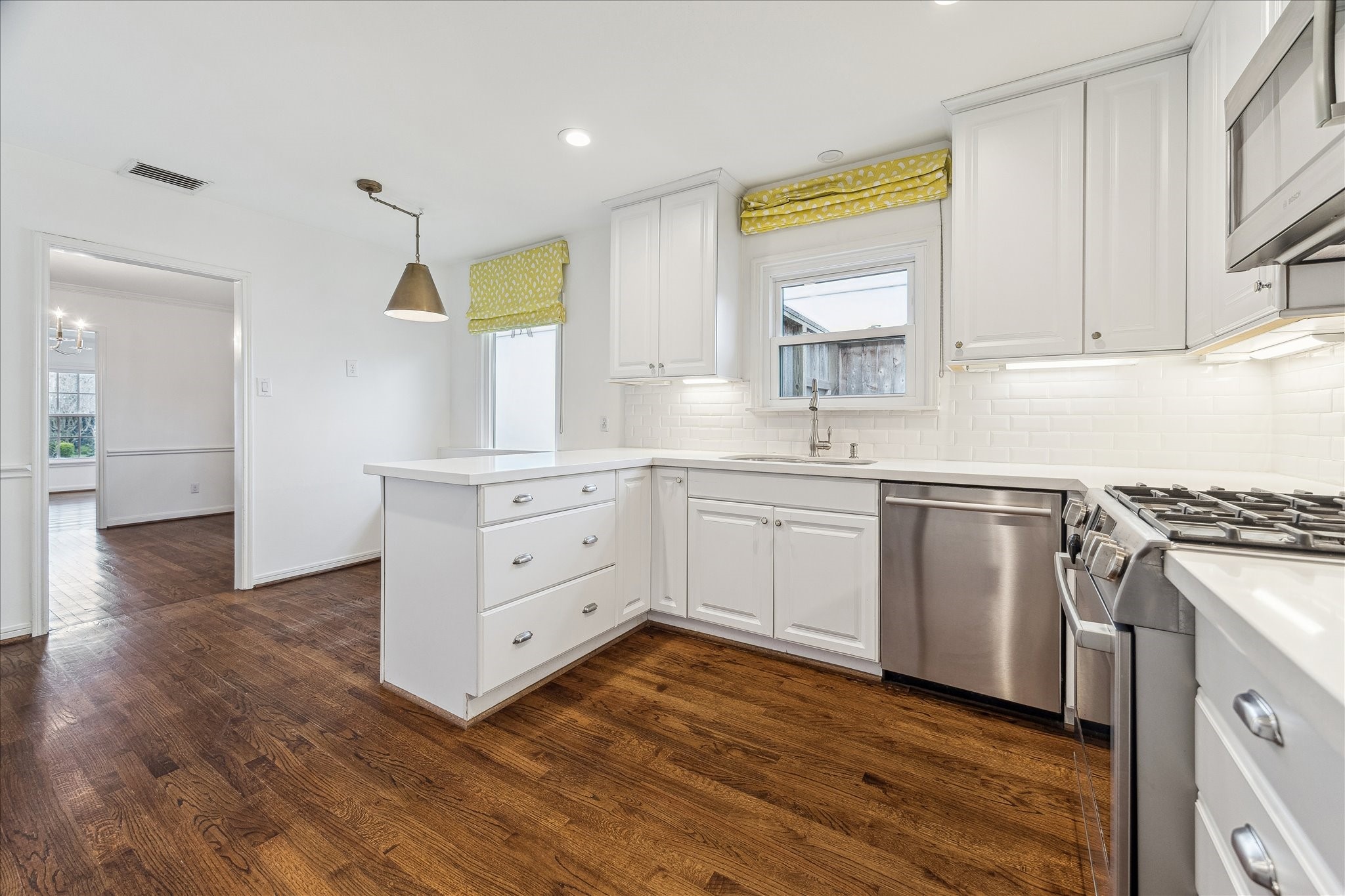 2820 Rice Boulevard West University Place, TX 77005 - Photo 9 of 37 KITCHEN. Fully updated with quartz countertops, tile backsplash, hardware, lighting and stainless steel appliances including a gas range.