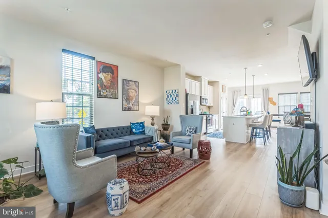 a living room with furniture a wooden floor and a potted plant