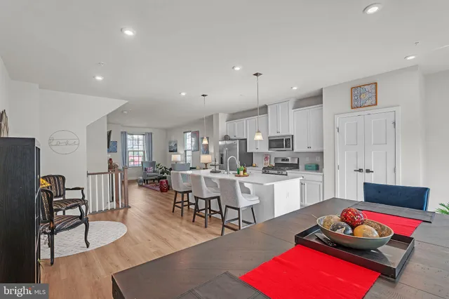 a living room with furniture flat screen tv and kitchen view