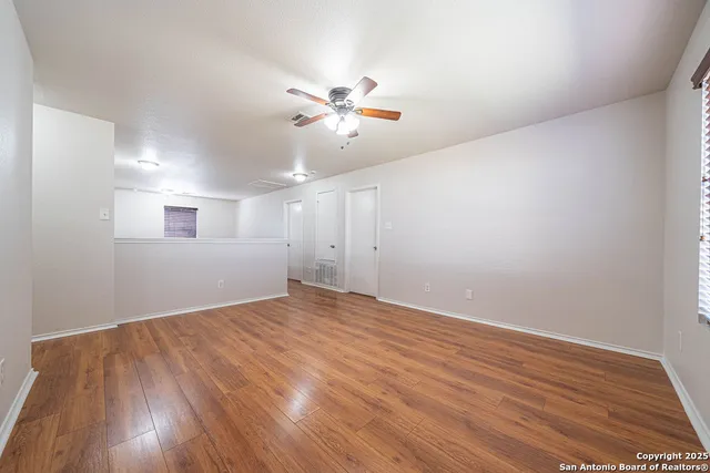 a view of an empty room with wooden floor