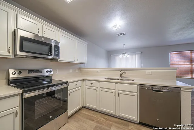 a kitchen with a sink stove and microwave