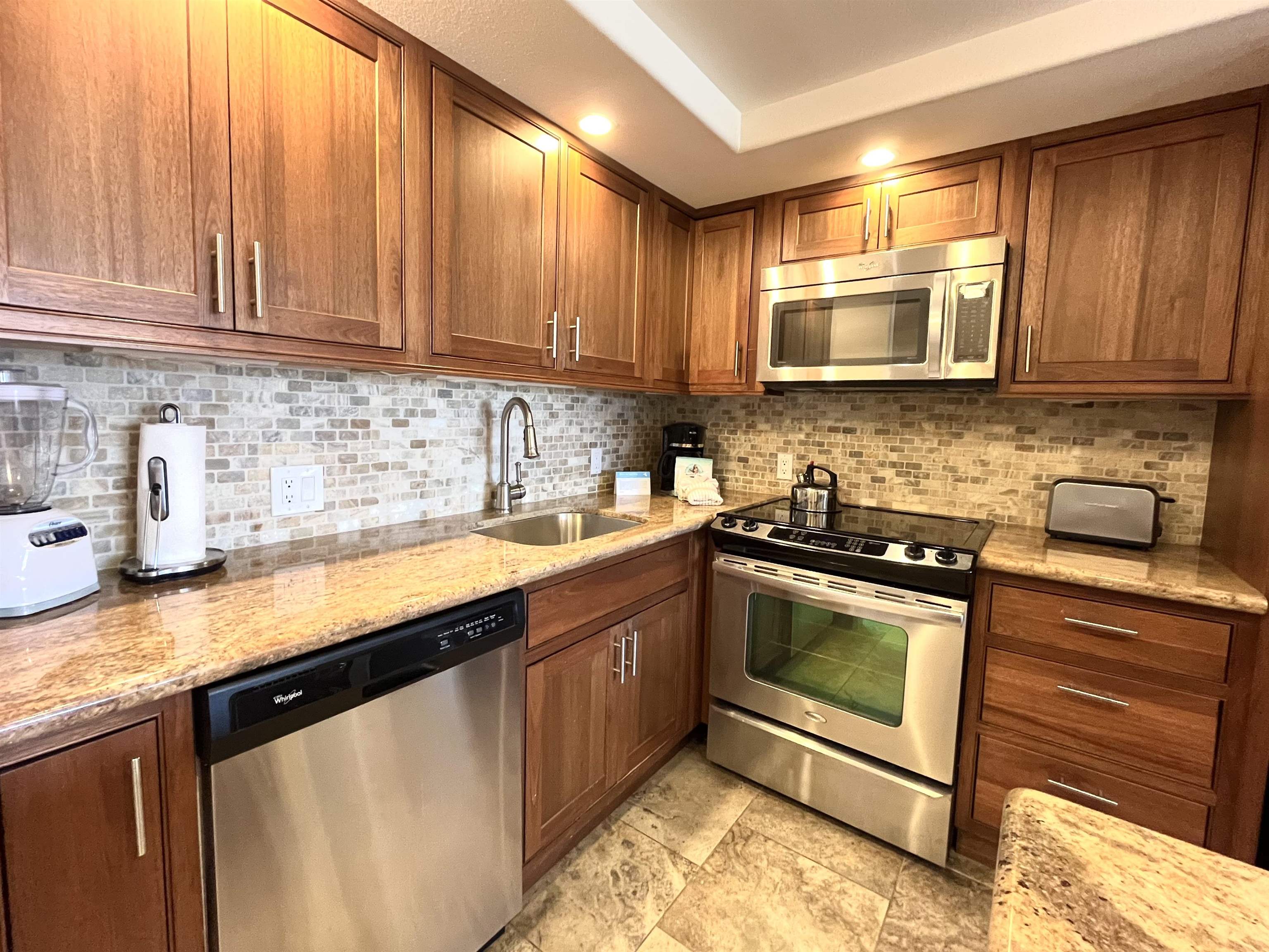 2575 South Kihei Road, Unit H414 Kihei, HI 96753 - Photo 3 of 30 a kitchen with stainless steel appliances granite countertop a sink stove and microwave