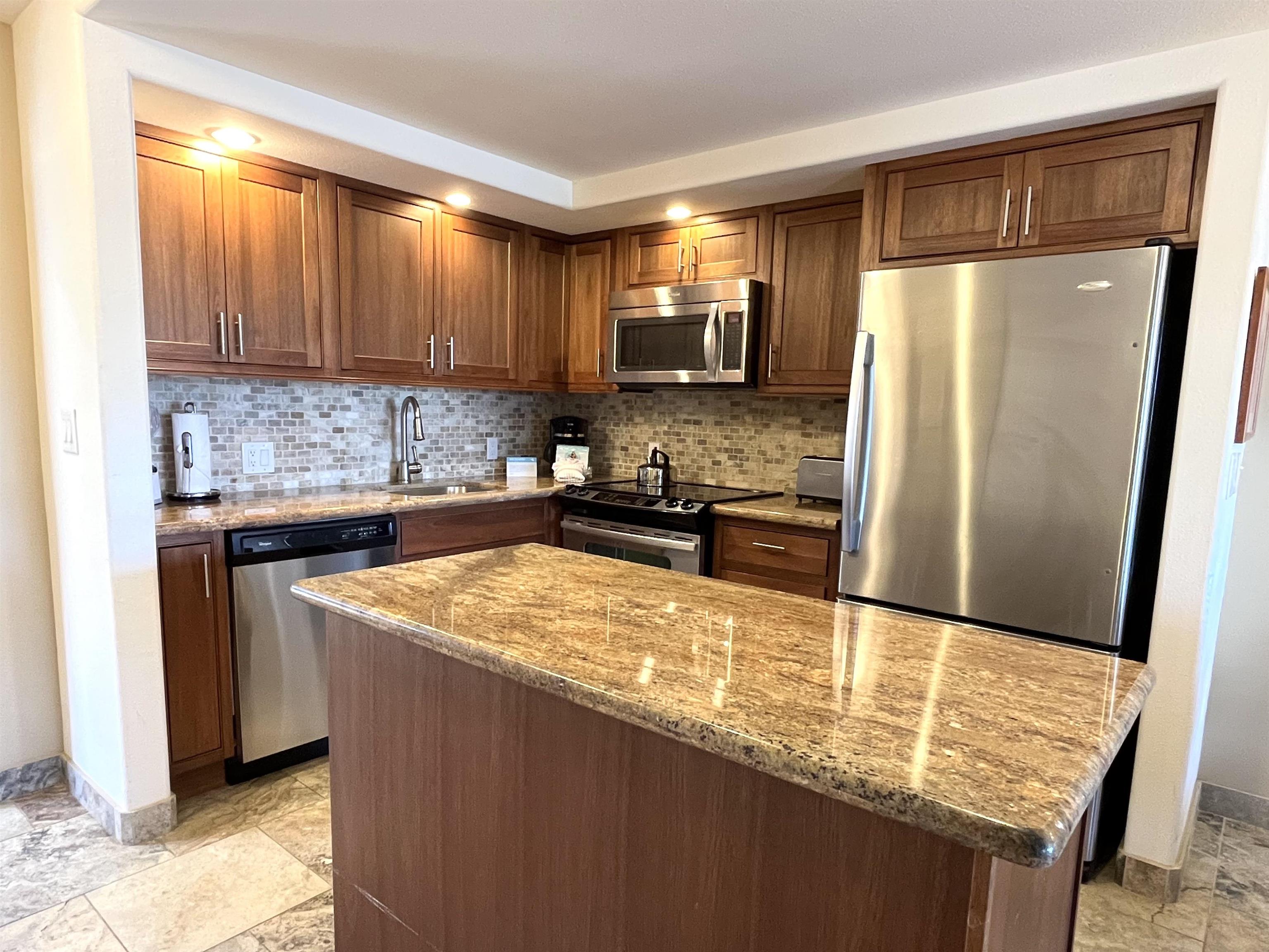 2575 South Kihei Road, Unit H414 Kihei, HI 96753 - Photo 4 of 30 a kitchen with stainless steel appliances granite countertop a sink stove and refrigerator