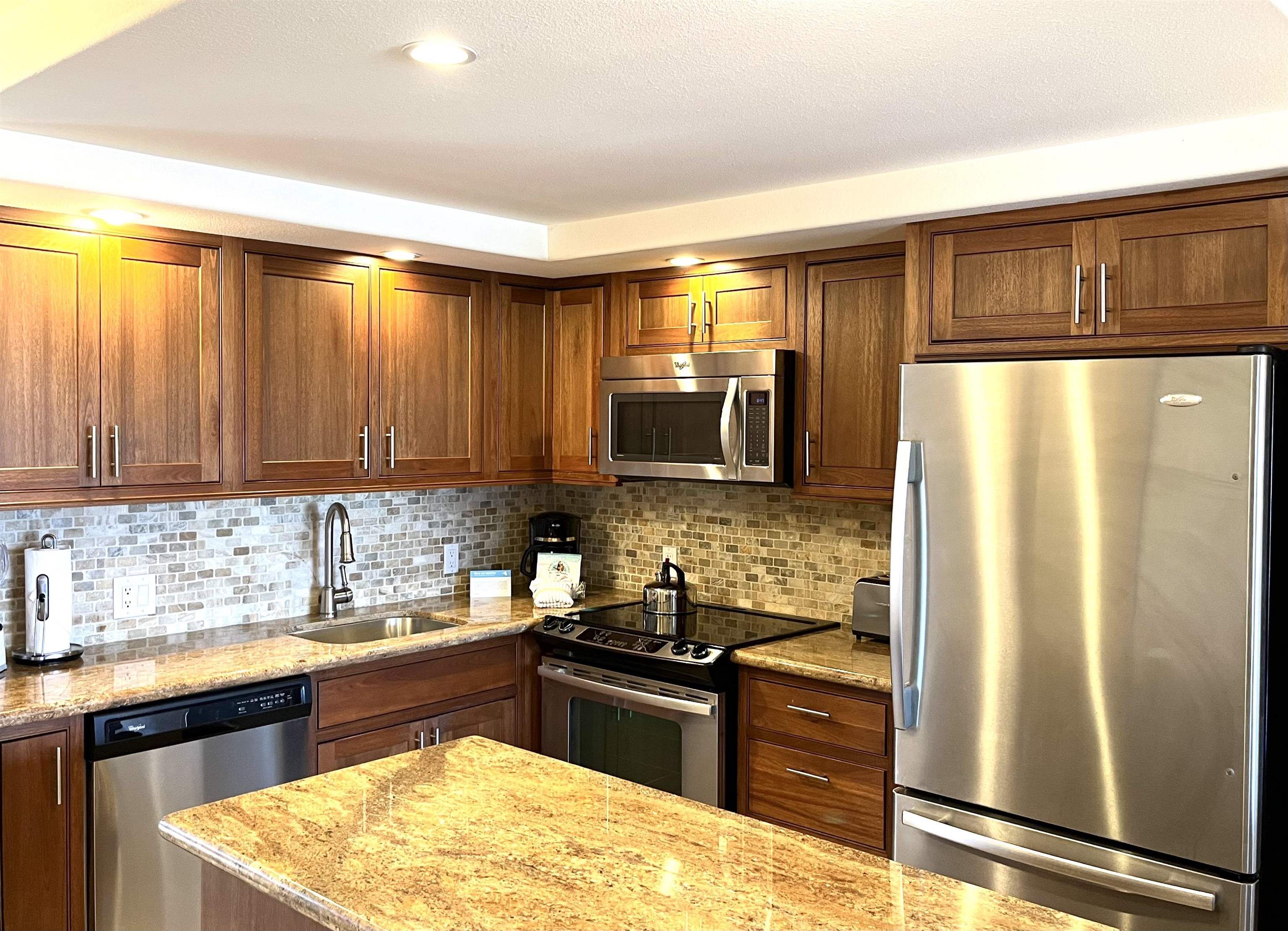 2575 South Kihei Road, Unit H414 Kihei, HI 96753 - Photo 5 of 30 a kitchen with stainless steel appliances granite countertop a refrigerator a sink and a stove
