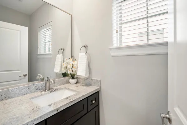a bathroom with a granite countertop sink and a mirror