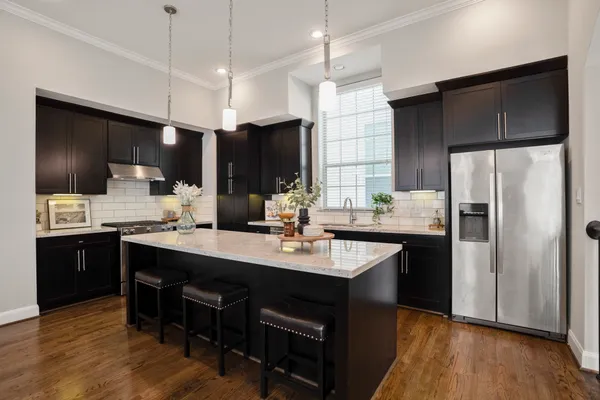 a kitchen with stainless steel appliances a sink a stove a refrigerator and cabinets