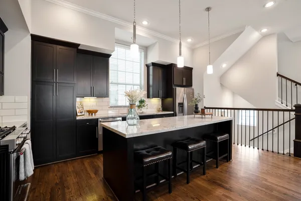 a kitchen with kitchen island a counter space a sink appliances and cabinets