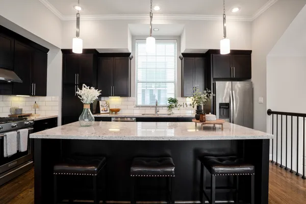 a kitchen with kitchen island granite countertop a sink cabinets and refrigerator