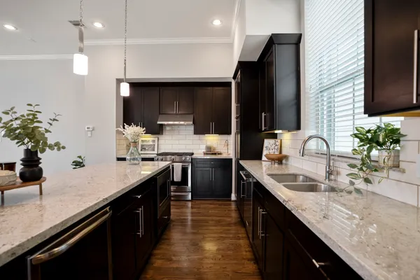 a kitchen with kitchen island granite countertop a sink stainless steel appliances and cabinets
