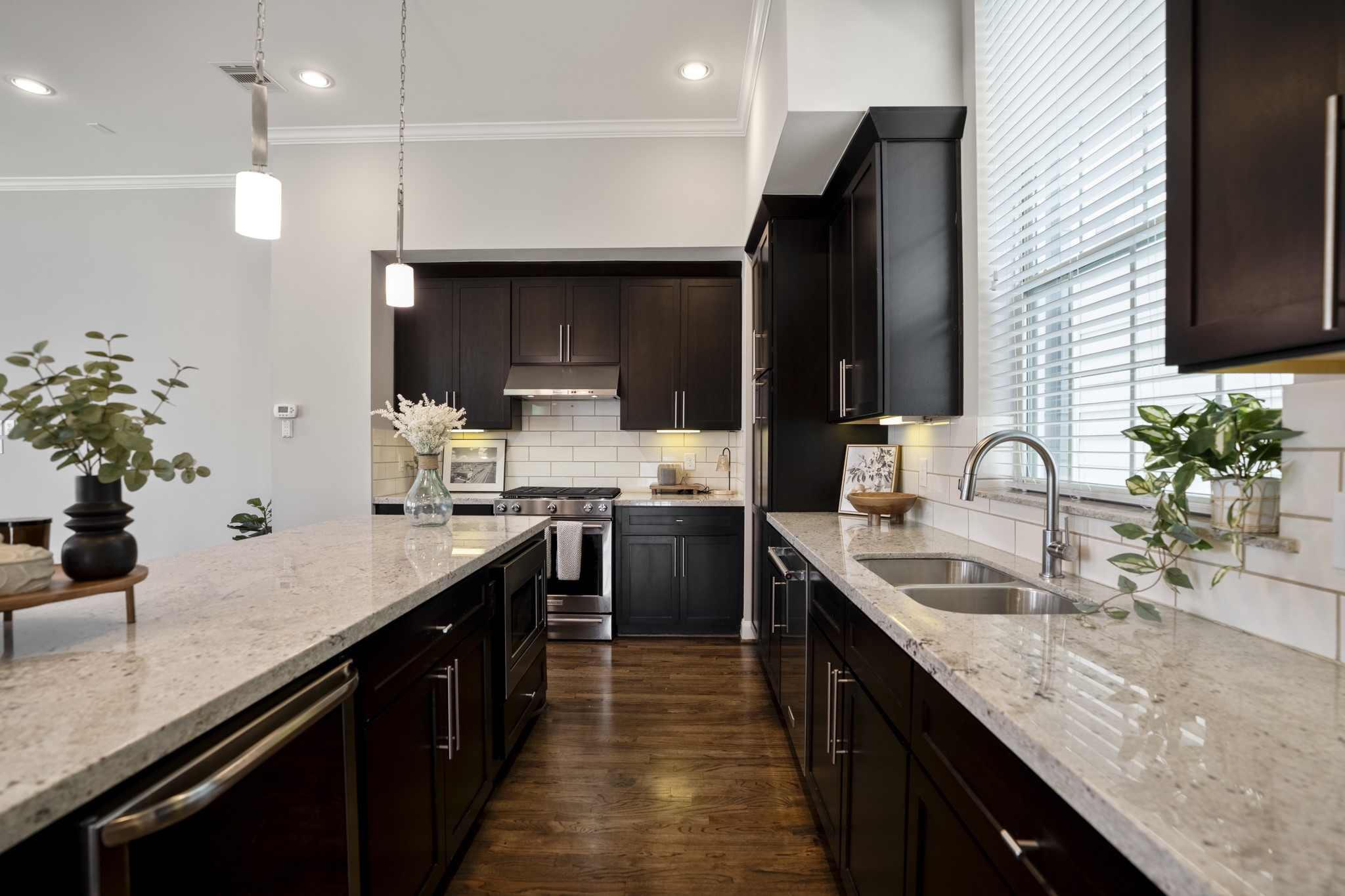 1032 West 26th Street, Unit D Houston, TX 77008 - Photo 17 of 42 a kitchen with kitchen island granite countertop a sink stainless steel appliances and cabinets