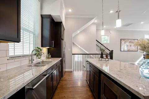 a kitchen with granite countertop a sink a counter top space and stainless steel appliances
