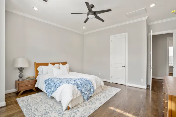 a bedroom with a large bed and wooden floor