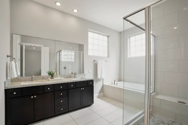 a bathroom with a double vanity sink mirror double and shower