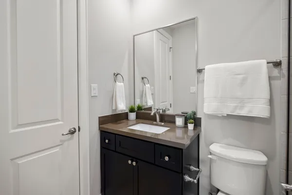 a bathroom with a granite countertop sink toilet and mirror