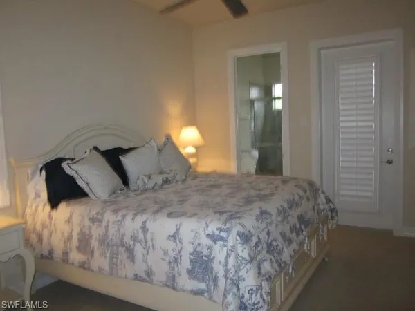 a bed sitting in a bedroom next to a lamp